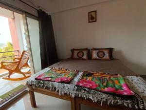 a bedroom with a bed with a table and a window at Dapolihideaway in Dapoli