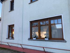 a window of a white building with two potted plants at Ferienwohnung in Cammer