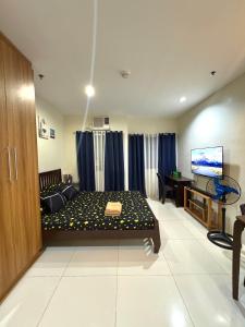 a room with a bed and a television in it at The Midpoint Residences - Studio Unit in Cebu City