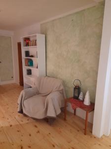 a living room with a chair and a book shelf at Große Ferienwohnung 160qm in einzigartigem historischen 700 Jahre altem Gebäude in Hardegsen