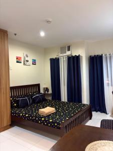 a bedroom with a bed with blue curtains at The Midpoint Residences - Studio Unit in Cebu City +16 photos