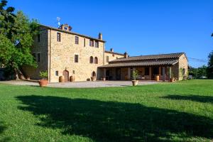 a large brick building with a large grass yard at Agriturismo Podere Santo Stefano in Cinigiano