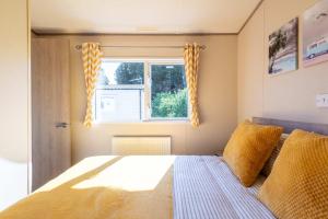 a bedroom with a bed and a window at Peaceful Spot at Seton Sands 3-Bed Caravan near Edinburgh in Port Seton