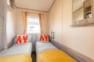 a room with two beds and a window at Peaceful Spot at Seton Sands 3-Bed Caravan near Edinburgh in Port Seton