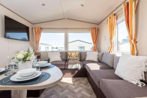 a living room with a couch and a table at Peaceful Spot at Seton Sands 3-Bed Caravan near Edinburgh in Port Seton