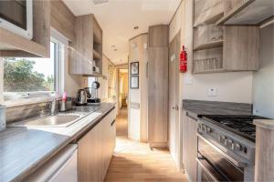 a kitchen with a sink and a stove at Peaceful Spot at Seton Sands 3-Bed Caravan near Edinburgh in Port Seton +17 photos