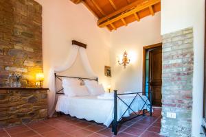 a bedroom with a bed and a stone wall at Agriturismo Podere Santo Stefano in Cinigiano +35 photos