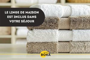 a stack of white towels on a shelf at Le Petit Cocon - Lumineux & Confortable in Cerizay