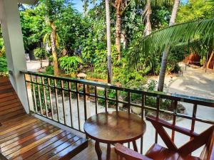 a porch with a table and chairs on a balcony at Kirati Beach Resort in Choeng Mon Beach