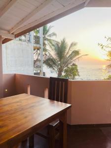 a wooden table with a view of the ocean at Reef Inn by COOP in Hikkaduwa