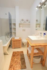 a bathroom with a sink and a tub and a toilet at Quantic Apartment in Warsaw