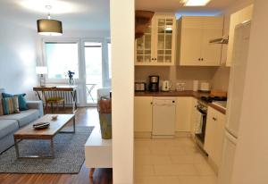 cocina y sala de estar con sofá y mesa en Quantic Apartment, en Varsovia