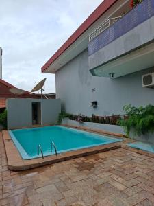 a swimming pool in front of a building at Pousada dos Girassóis in Palmas