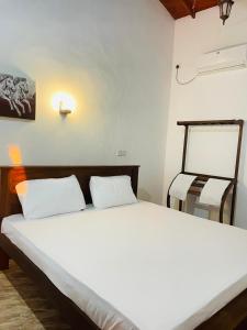 a bed with two white pillows in a room at Reef Inn by COOP in Hikkaduwa