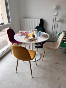 a dining room table with chairs and a table with dishes on it at Pop Mood Studio in Heillecourt
