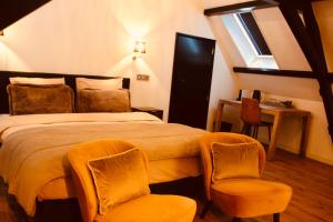 a hotel room with a bed and two chairs at Herberg De Hollandsche Leeuw in Nieuwkoop