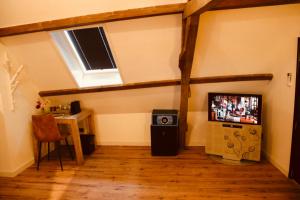 a room with a tv and a table and a window at Herberg De Hollandsche Leeuw in Nieuwkoop