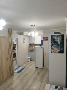 a kitchen with a white refrigerator in a room at Лукс Апартамент Морска Перла in Primorsko