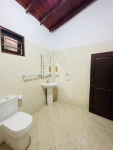 a bathroom with a toilet and a sink at Reef Inn by COOP in Hikkaduwa