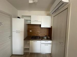 a small kitchen with white cabinets and a sink at Chalet del Sol in Fano +9 photos