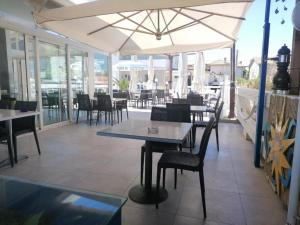 a restaurant with tables and chairs and an umbrella at Chalet del Sol in Fano