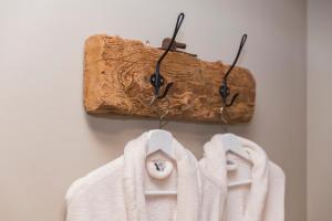 a towel rack with two white towels and a piece of wood at Het Stalhuys in Reeuwijk