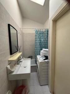 a bathroom with a sink and a toilet and a mirror at Chalet del Sol in Fano