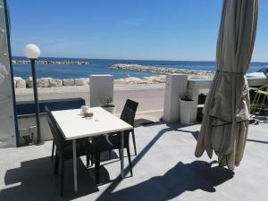a table and chairs and an umbrella and the beach at Chalet del Sol in Fano
