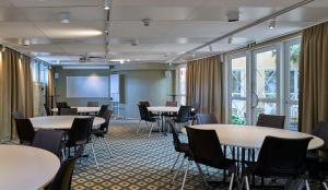 a conference room with tables and chairs and a screen at Scandic Skellefteå in Skellefteå +50 photos