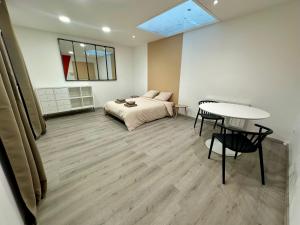 a room with a bed and a table in it at Le Lido Maison 6 personnes in Saint-Varent