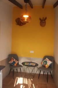 two chairs and a table in a room with a yellow wall at Casa Ruby in Huércal-Overa