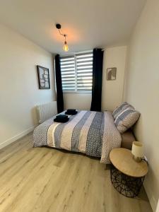 a bedroom with a bed and a wooden floor at Le Lido Maison 6 personnes in Saint-Varent
