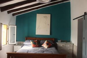 a bedroom with a bed and a blue wall at Casa Ruby in Huércal-Overa