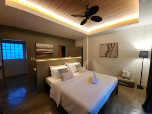 a bedroom with a bed with a ceiling fan at Hazel's Suites in Dauin