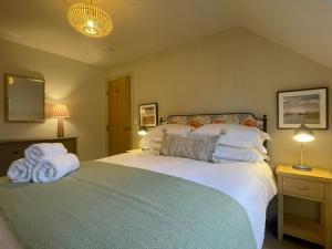 a bedroom with a large bed with towels on it at Catbells in Keswick