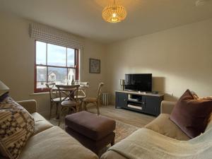 a living room with a couch and a table at Catbells in Keswick