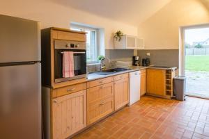 a kitchen with a refrigerator and a sink at AR PENNITI - Magnifique maison en pierre proche plage in Landéda +39 photos