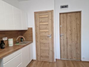 a kitchen with a wooden door next to a sink at Dzień dobry w Szczytnej in Szczytna