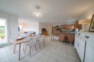 a kitchen and living room with a table and chairs at TY BIHAN - Charmante maison de plein-pied proche mer in Ploudalmézeau