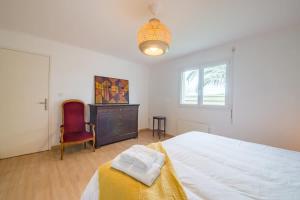 a bedroom with a bed and a chair and a window at TY BIHAN - Charmante maison de plein-pied proche mer in Ploudalmézeau +42 photos