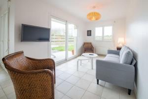 a living room with a couch and a tv at TY BIHAN - Charmante maison de plein-pied proche mer in Ploudalmézeau