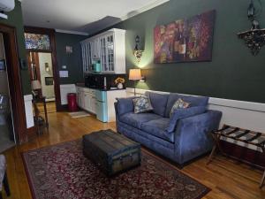 a living room with a blue couch and a kitchen at Firehouse Inn in Barre