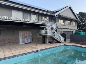 a house with a swimming pool and a staircase next to a house at G - Boutique in Durban