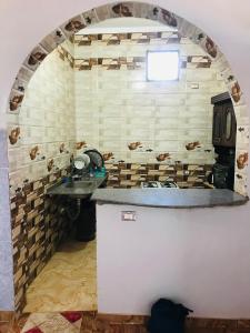 a kitchen with a sink and a brick wall at Nubian house in Jazīrat Salūjah