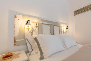 a white bedroom with a white bed with white pillows at Garden view in Cascais
