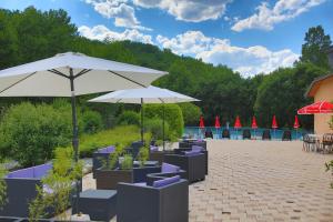 a patio with umbrellas and tables and chairs with boats at Chambres les 4 saisons in Oust