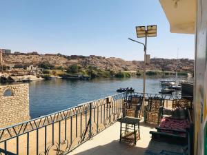 a balcony with chairs and a view of a river at Nubian house in Jazīrat Salūjah