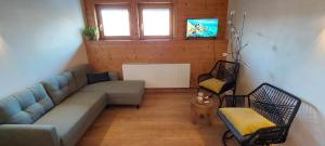a living room with a couch and two chairs at Landhaus Rickies in Aifersdorf