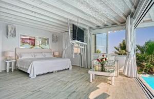 a white bedroom with a bed and a large window at Zinas Villas in Fanari +140 photos
