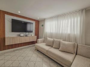a living room with a couch and a flat screen tv at Margarita 93 in Barranquilla